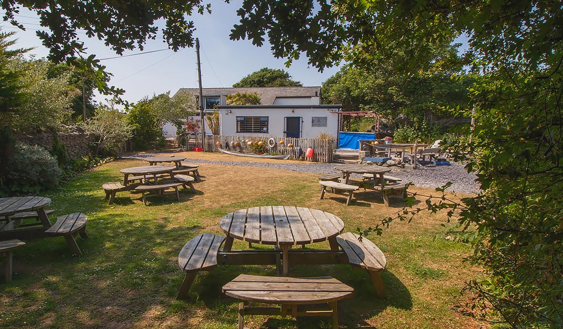 The Paddlers Return outdoor seating area with dappled shade from the tress